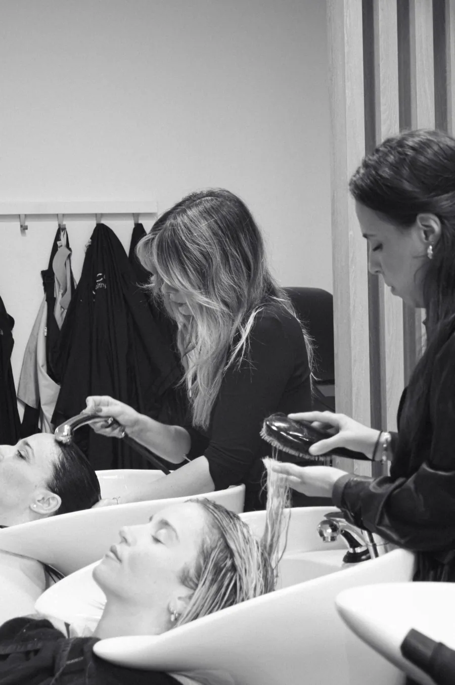 Stylistes autour d'une cliente dans le salon